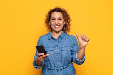 İspanyol orta yaşlı kadın gülümsüyor ve arkadaş canlısı görünüyor, bir numara veya ilk eli önde, geriye doğru sayıyor.