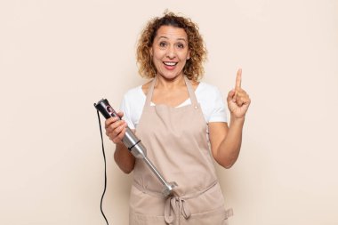 İspanyol orta yaşlı kadın bir fikri fark ettikten sonra mutlu ve heyecanlı bir dahi gibi hissediyor, neşeli bir şekilde parmağını kaldırıyor, eureka!