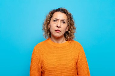 middle age woman feeling puzzled and confused, with a dumb, stunned expression looking at something unexpected