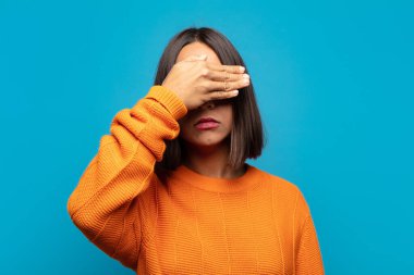 İspanyol kadın tek eliyle gözlerini kapatıyor korkmuş ya da endişeli hissediyor, merak ediyor ya da körü körüne bir sürpriz bekliyor.