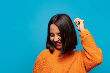 İspanyol kadın gülümsüyor, kaygısız hissediyor, rahat ve mutlu, dans ediyor ve müzik dinliyor, bir partide eğleniyor.