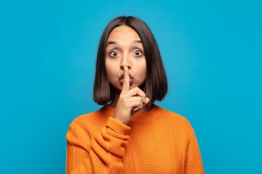 İspanyol kadın ciddi görünüyor ve parmaklarını dudaklarına bastırıp sessizlik ya da sessizlik talep ediyor, sır saklıyor.