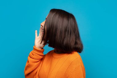 İspanyol kadın profil görüşü, mutlu ve heyecanlı görünüyor, bağırıyor ve kenardaki boşluğu kopyalamak için arıyor