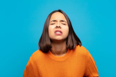 Hispanik kadın endişeli, hasta, hasta ve mutsuz hissediyor. Ağrılı bir mide ağrısı veya grip geçiriyor.