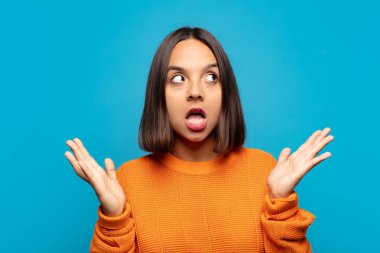 İspanyol kadın şaşkın ve şaşkın bakıyor, inanılmaz bir şey fark ettiğinde çene şaşkın