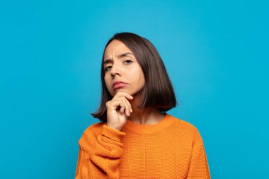 İspanyol kadın ciddi görünüyor, kafası karışık, kararsız ve düşünceli, seçenekler ya da seçimler arasında şüpheci