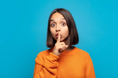 İspanyol kadın sessizlik ve sessizlik istiyor, parmaklarıyla ağzının önünde işaret ediyor, 