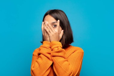 İspanyol kadın korkmuş ya da utanmış hissediyor. Gözleri yarı kapalı ya da elleri kapalı dikizliyor ya da dikizliyor.