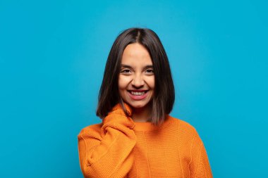 İspanyol kadın neşeli ve kendinden emin bir şekilde gülüyor. Sıradan, mutlu, dostane bir gülümsemeyle.