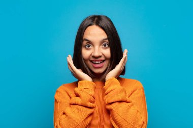 İspanyol kadın beklenmedik bir sürprizden dolayı şaşkın, heyecanlı, gülen, şaşkın ve mutlu hissediyor.