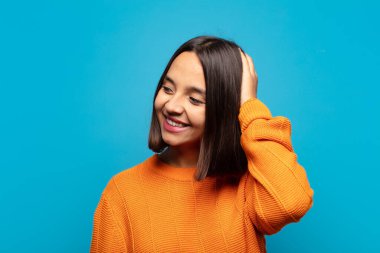 İspanyol kadın neşeli ve sıradan bir şekilde gülümsüyor, olumlu, mutlu ve kendinden emin bir bakışla yumruk yumruğa.