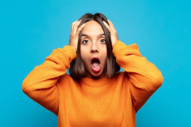 Hispanik kadın dehşete kapılmış ve şok olmuş hissediyor, ellerini havaya kaldırıyor ve bir hata yüzünden panikliyor.