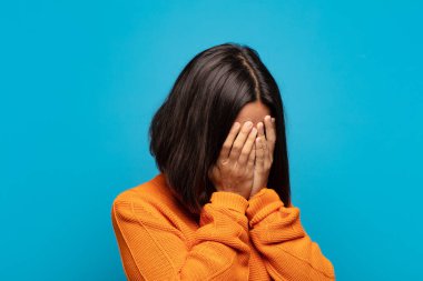 İspanyol kadın, üzgün, hayal kırıklığına uğramış bir bakışla gözlerini kapatıyor, ağlıyor, yan gözle bakıyor.