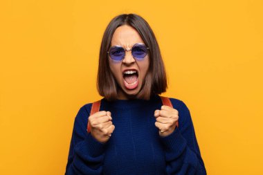 İspanyol kadın sinirli, sinirli, sinirli bakışlar ve sıkı yumruklar ile agresif bir şekilde bağırıyor.