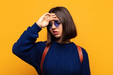 İspanyol kadın stresli, yorgun ve hayal kırıklığına uğramış görünüyor, alnından ter damlıyor, umutsuz ve bitkin hissediyor.