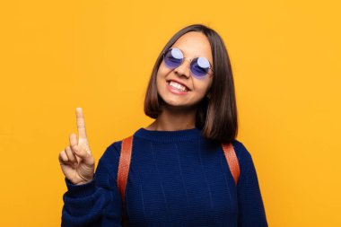 İspanyol kadın gülümsüyor ve arkadaş canlısı görünüyor, bir numara ya da ilk eli önde, geriye doğru sayıyor.