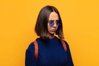 Hispanik kadın üzgün, üzgün ya da kızgın ve olumsuz bir tavır takınıyor, anlaşmazlık içinde kaşlarını çatıyor.