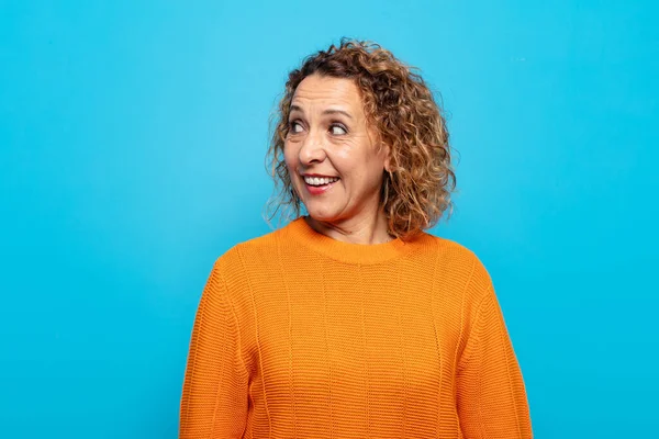 Orta yaşlı kadın şaşkın, mutlu, şaşkın ve şaşırmış hissediyor, ağzı açık bir şekilde yana bakıyor.