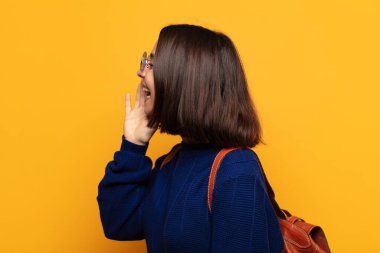 İspanyol kadın profil görüşü, mutlu ve heyecanlı görünüyor, bağırıyor ve kenardaki boşluğu kopyalamak için arıyor