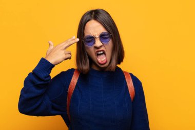 İspanyol kadın mutsuz ve stresli görünüyor, intihar jesti elle silah işareti yapıyor, kafasını işaret ediyor.