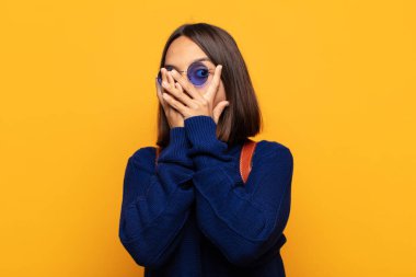 İspanyol kadın korkmuş ya da utanmış hissediyor. Gözleri yarı kapalı ya da elleri kapalı dikizliyor ya da dikizliyor.