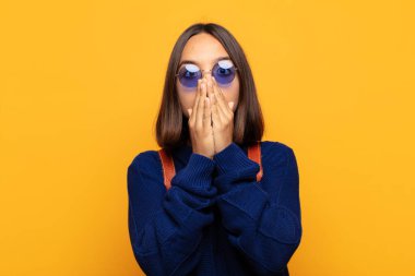 İspanyol kadın endişeli, üzgün ve korkmuş hissediyor, elleriyle ağzını kapatıyor, endişeli ve berbat görünüyor.