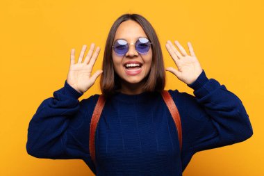 İspanyol kadın panik ya da öfke içinde bağırıyor, şok olmuş, korkmuş ya da öfkeli, elleri başının yanında.