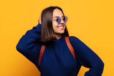 İspanyol kadın neşeli ve sıradan bir şekilde gülümsüyor, olumlu, mutlu ve kendinden emin bir bakışla yumruk yumruğa.