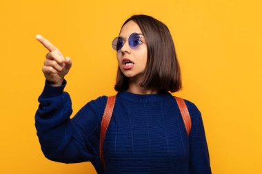 İspanyol kadın şaşkın ve şaşırmış hissediyor, şaşırmış ve hayranlıkla yukarı bakıyor, şaşkın, açık ağızlı bir bakışla