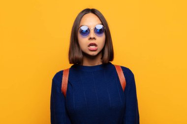 İspanyol kadın şaşkın, mutlu, şaşkın ve şaşırmış hissediyor, ağzı açık bir şekilde yana bakıyor.