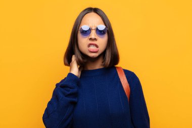 İspanyol kadın kendini stresli, hayal kırıklığına uğramış ve yorgun hissediyor. Endişeli ve sorunlu bir bakışla boynunu okşuyor.