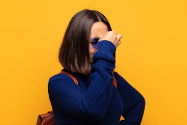 İspanyol kadın stresli, mutsuz ve hayal kırıklığına uğramış, alnına dokunuyor ve şiddetli baş ağrısı çekiyor.