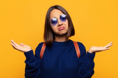 İspanyol kadın şaşkın ve şaşkın hissediyor, doğru cevap ya da karardan emin değil, bir seçim yapmaya çalışıyor.