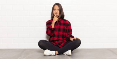 Şaşırmış, gergin, endişeli ya da korkmuş bakışları olan İspanyol bir kadın kopya boşluğuna doğru bakıyor.