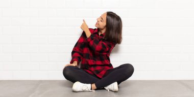 İspanyol kadın dikiz aynası ve fotokopi alanı üzerinde duran ve objeye işaret eden