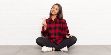 İspanyol kadın gülümsüyor ve mutlu görünüyor, kaygısız ve pozitif, zafer ya da barış simgesi.