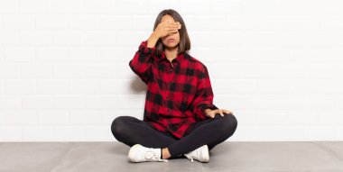 İspanyol kadın tek eliyle gözlerini kapatıyor korkmuş ya da endişeli hissediyor, merak ediyor ya da körü körüne bir sürpriz bekliyor.