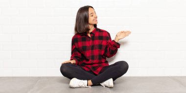 İspanyol kadın gülümsüyor, seni selamlıyor ve başarılı bir anlaşma için el sıkışmayı teklif ediyor.