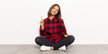 İspanyol kadın gülümsüyor ve arkadaş canlısı görünüyor, bir numara ya da ilk eli önde, geriye doğru sayıyor.