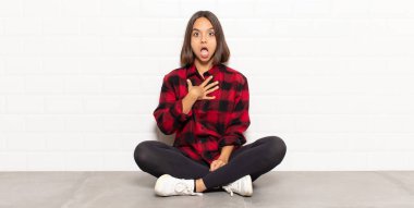 İspanyol kadın şok olmuş, şaşırmış ve şaşırmış hissediyor, elleri göğsünde ve ağzı açık, kim olduğunu söylüyor, ben mi??