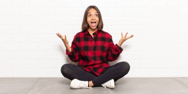 İspanyol kadın kendini mutlu, şaşkın, şanslı ve şaşırmış hissediyor. Zaferi kutlarken iki eli havada.