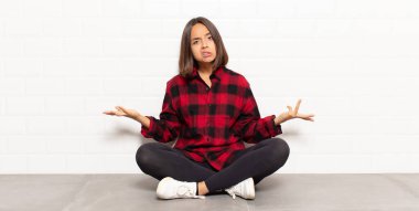 hispanic woman feeling clueless and confused, having no idea, absolutely puzzled with a dumb or foolish look