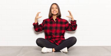 İspanyol kadın kendi gülüşünü çiziyor ya da özetliyor iki eliyle, olumlu ve mutlu görünüyor, sağIık kavramı.