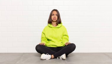 Hispanik kadın üzgün ve mızmızlanıyor, mutsuz bir bakışla, negatif ve hayal kırıklığına uğramış bir tavırla ağlıyor.