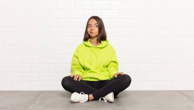 İspanyol kadın merak ediyor, mutlu düşünceler ve fikirler düşünüyor, hayal kuruyor, kenarda yer arıyor.