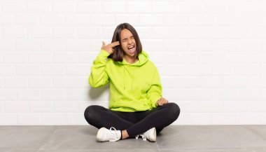 İspanyol kadın mutsuz ve stresli görünüyor, intihar jesti elle silah işareti yapıyor, kafasını işaret ediyor.