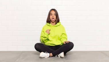 İspanyol kadın şok olmuş ve şaşırmış görünüyor, ağzı açık, kendini işaret ediyor.