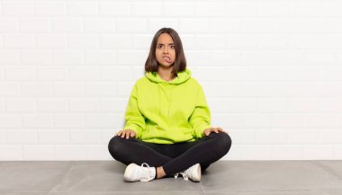 İspanyol kadın şaşkın ve şaşkın görünüyor. Sinirli bir hareketle dudağını ısırıyor. Sorunun cevabını bilmiyor.