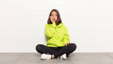 İspanyol kadın şoke olmuş ve ağzı açık bir şekilde yüz yüze inanamamaktan hayrete düşmüş.