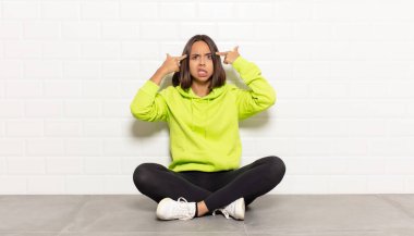 Ciddi ve konsantre bakışlı İspanyol kadın, beyin fırtınası yapıyor ve zorlu bir sorunu düşünüyor.